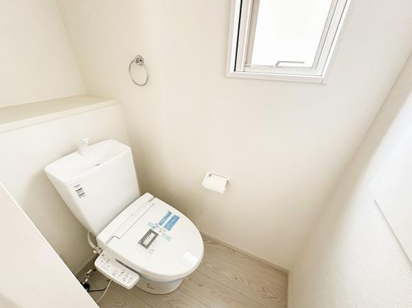 トイレ用品の整理に便利な収納棚付き。窓も設けられており、清潔な空間の印象です。 【内外観】トイレ